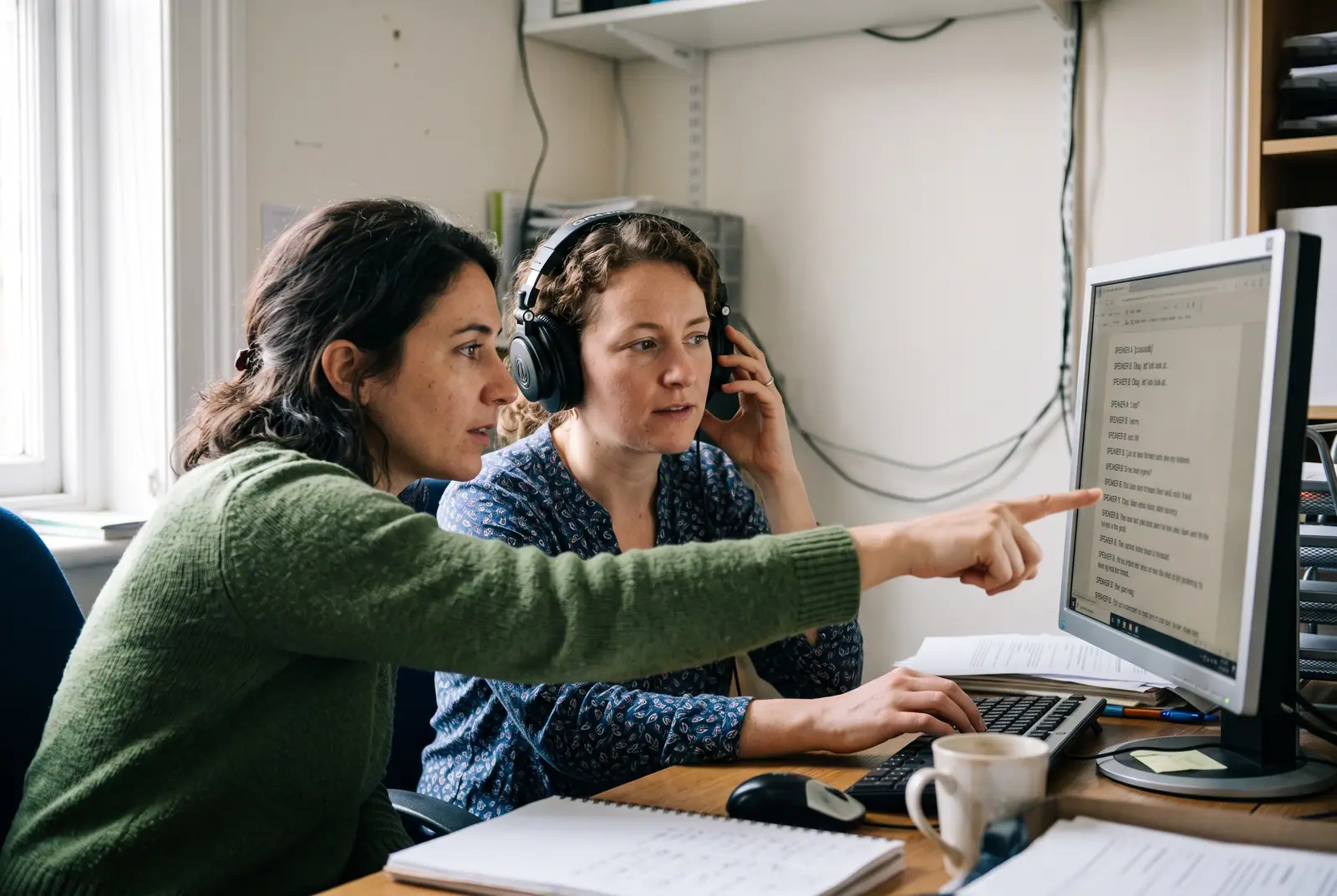 Two reviewers checking a transcript together on one screen